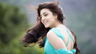 Joyful Indian Actress Kajal Aggarwal Posing Outdoors with Flowing Hair image