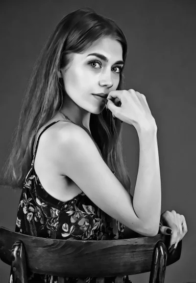 Pensive Young Woman Posing Elegantly on Chair Black and White Portrait image
