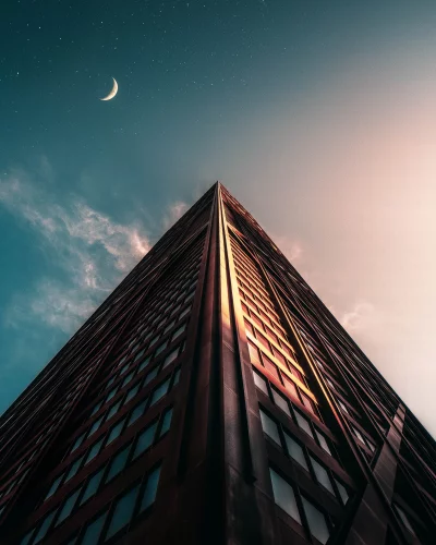 Modern Skyscraper Towering Towards Crescent Moon and Starry Twilight Sky image
