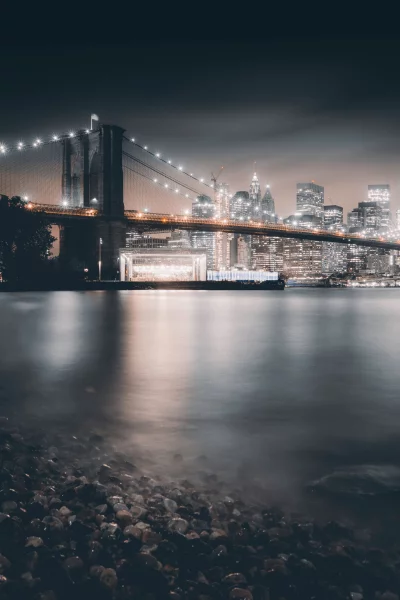 Iconic Brooklyn Bridge and Downtown Manhattan Night Skyline Reflecting on East River image