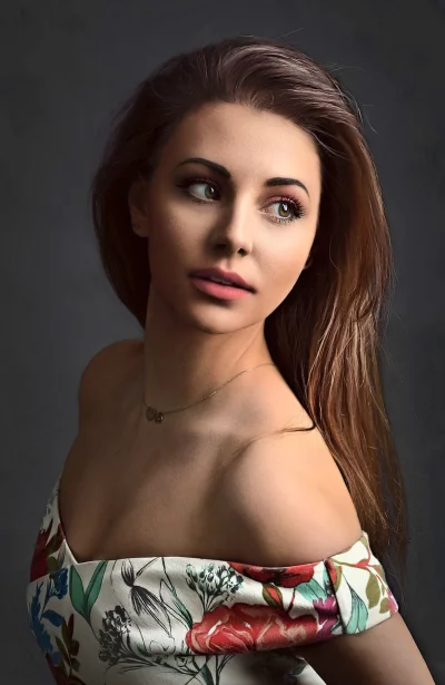 Serene Woman in Floral Off-Shoulder Dress with Thoughtful Gaze Portrait image