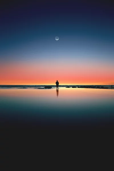Lonely Figure Under Crescent Moon at Sunset with Water Reflection image