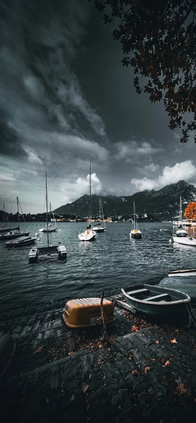 Sailboats Moored on a Lake Under Dramatic Cloudy Sky with Autumn Foliage