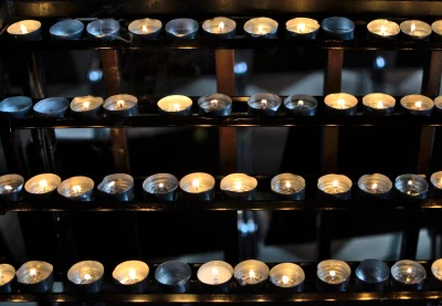 Rows of Glowing Votive Candles in a Dark Spiritual Setting image