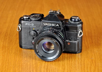 Vintage Yashica FX-D Quartz 35mm SLR Film Camera on Wooden Background image