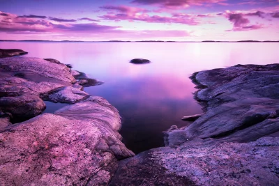 Mesmerizing Purple Pink Sunset over Serene Ocean with Rugged Coastal Rocks and Distant Horizon image