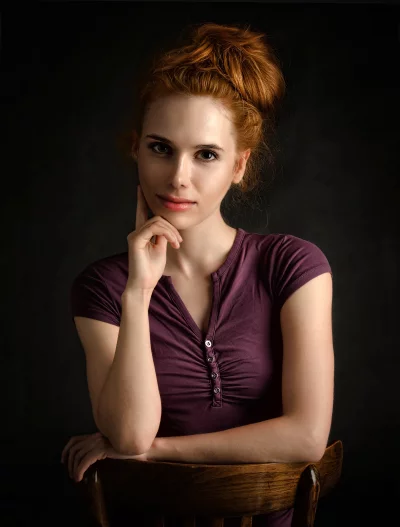 Pensive Redhead Woman with Messy Bun in Thoughtful Studio Portrait image