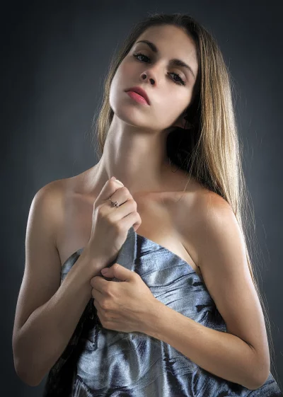 Captivating Young Woman in Shimmering Blue Fabric Portrait image