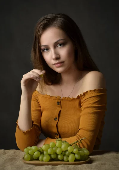 Captivating Woman in Off-Shoulder Top Posing with Fresh Green Grapes image