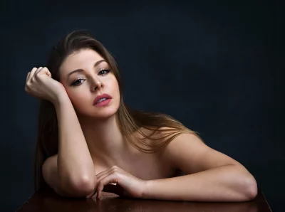 Pensive Woman with Long Brown Hair Resting Head on Hand image