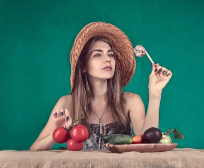 Young Woman in Straw Hat Pondering Garlic Amidst Fresh Vegetables image