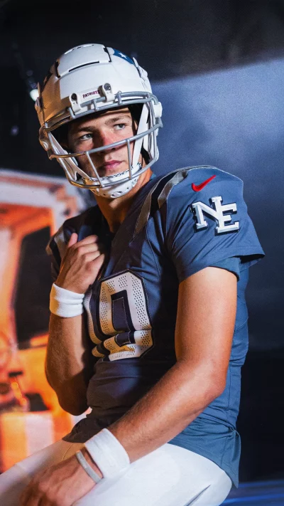 Determined Young American Football Player in Patriots Helmet and Blue Jersey