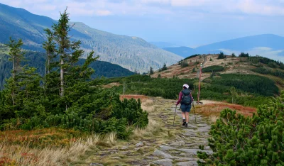 Adventurous Woman Hiking Mountain Path Scenic Landscape Nature Wallpaper image