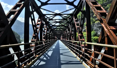 Historic Rusty Metal Truss Bridge Pathway Through Green Mountain Valley image