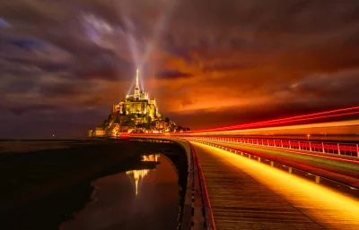 Mont Saint Michel Illuminated at Night with Dynamic Light Trails on the Bridge Cinematic Wallpaper Style image