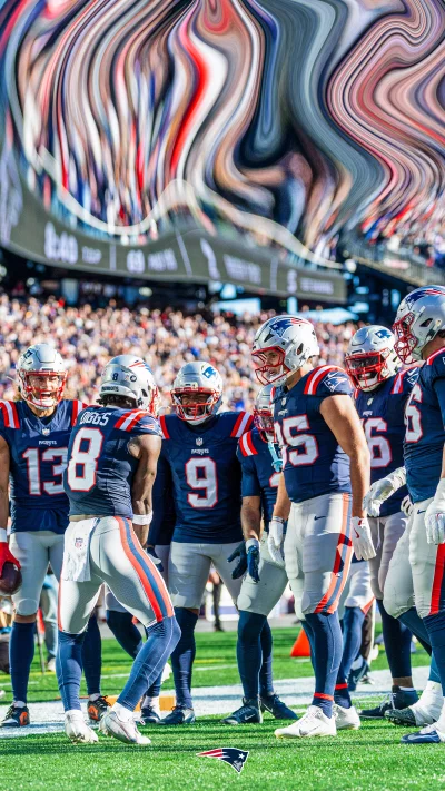 New England Patriots Football Players Huddle on Field During Sunny Game Day image