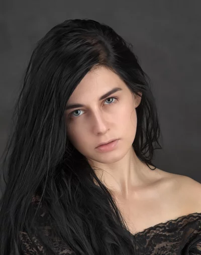 Mesmerizing Portrait of Young Woman with Dark Hair and Striking Blue Eyes image