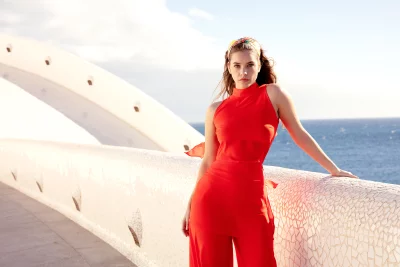 Stylish Woman in Red Ensemble Posing Confidently by Mosaic Ocean View image
