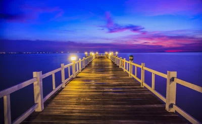 Long Wooden Pier Illuminated at Twilight with Vibrant Sunset Sky image