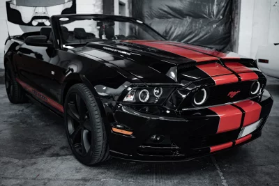 Sleek Black Ford Mustang Convertible with Dynamic Red Racing Stripes image