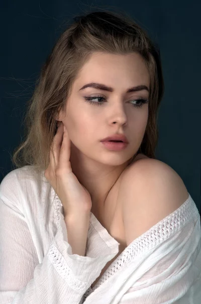 Pensive Woman in White Crinkled Off-Shoulder Top Portrait image