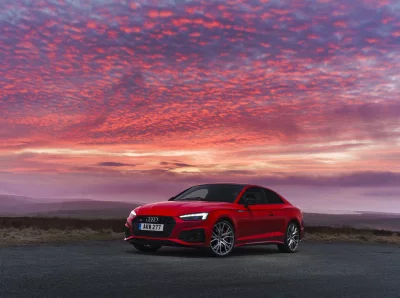 Red Audi S5 Sportback Parked Under a Breathtaking Dramatic Sunset Sky with Vibrant Clouds image