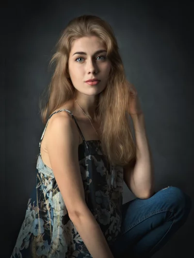 Captivating Young Woman with Blonde Hair Posing Thoughtfully in Floral Top image