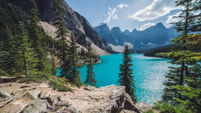Majestic Turquoise Glacial Lake Surrounded by Towering Mountains and Evergreen Forests image
