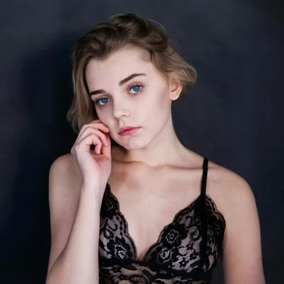Young woman with blue eyes and blonde hair in black lace lingerie