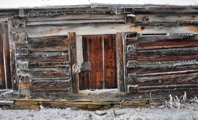 Rustic Frosted Log Cabin Wall in Winter with Wooden Door image