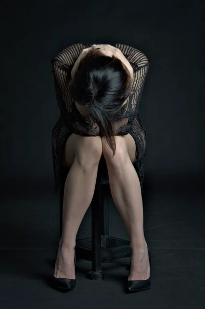 Distressed Woman Sitting with Head Buried in Arms on Knees image