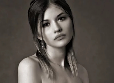 Elegant Sepia-Toned Portrait of a Pensive Young Woman with Bare Shoulders image