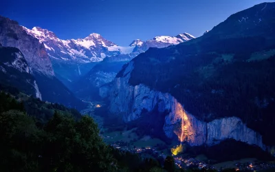 Stunning Alpine Valley at Night with Starry Sky and Glowing Waterfall in Switzerland image
