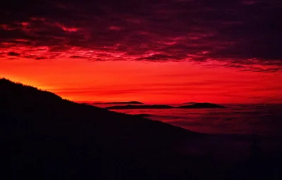 Vibrant Red Sky Sunset Above Silhouetted Mountains and Foggy Valleys image