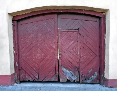 Weathered Red Wooden Door with Intricate Diamond Pattern and Small Entryway image