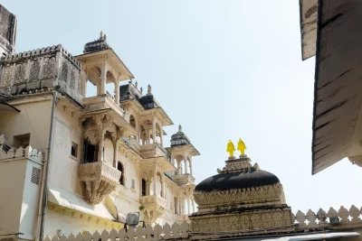 Historic Indian Palace Architecture with Ornate Balconies and Intricate Carvings Against Clear Sky image