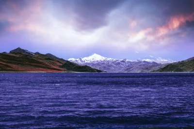 Dramatic Mountain Lake Landscape with Snowy Peaks and Purple Twilight Sky image