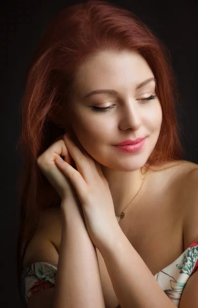 Beautiful Redhead Woman with Closed Eyes, Serene Expression and Gentle Hands image
