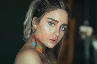 Captivating Woman with Vibrant Face Glitter Art and Piercing Gaze image