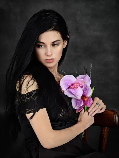 Pensive Woman with Long Dark Hair and Purple Orchids Portrait image