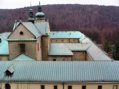 Historic Monastery Complex with Patina Copper Roofs Nestled Against Autumn Forest Hillside image