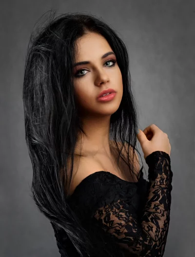 Captivating Young Woman in Black Lace Dress with Direct Gaze image