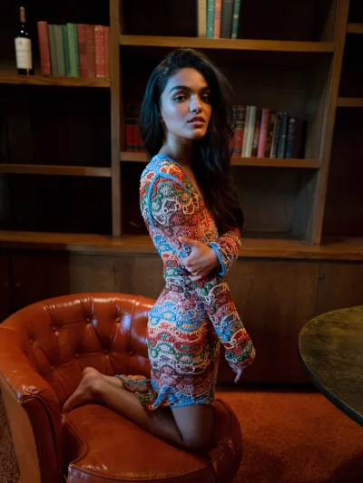 Captivating Woman in Hand-Knit Dress Posing on Vintage Leather Chair image