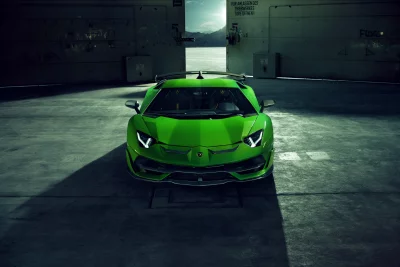 Dynamic Green Lamborghini Sports Car Emerging from Dark Industrial Hangar image