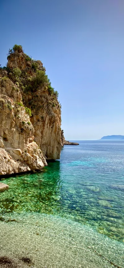 Crystal Clear Mediterranean Waters and Rugged Coastal Cliffs Under Blue Sky