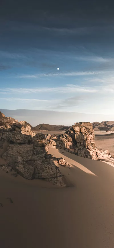 Moonlit Desert Rock Formation at Dusk with Streaky Clouds