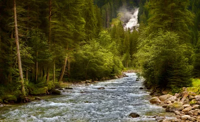 Alpine River Cascading Through Lush Green Forest with Distant Waterfall image