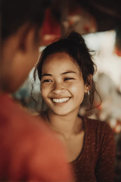 Joyful Young Asian Woman with Freckles Smiling Candidly in Natural Light