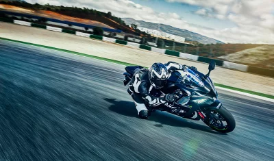 Professional Motorcycle Racer Leaning into a High-Speed Turn on a Dynamic Race Track image