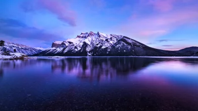 Majestic Snow-Capped Mountain Peaks Reflected in Tranquil Purple Lake at Twilight image